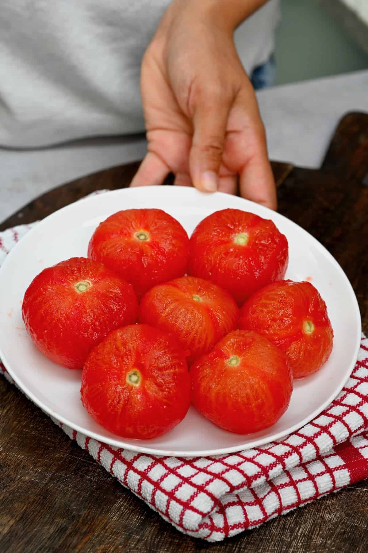 Seven peeled tomatoes on a plate