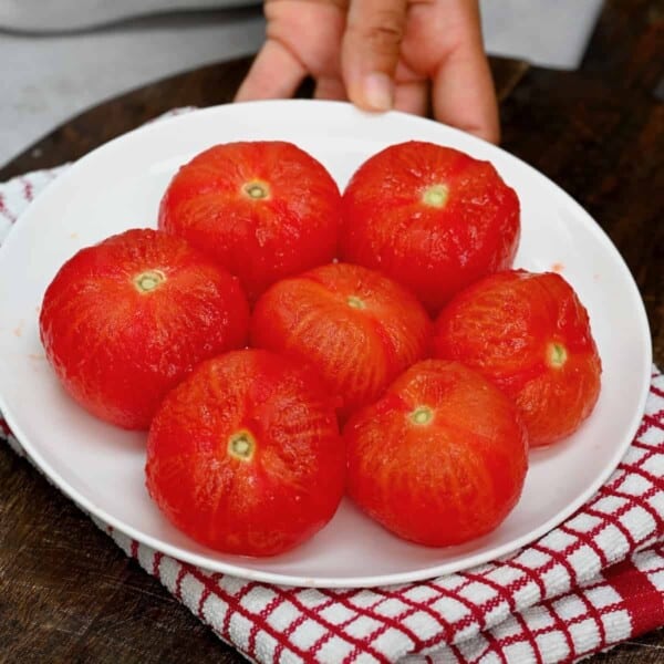 Seven peeled tomatoes on a plate