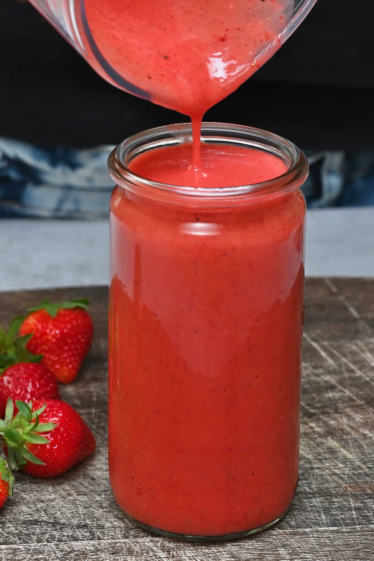 Pouring strawberry vinaigrette in a jar