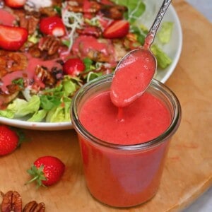 A spoonful of homemade strawberry vinaigrette over a jar