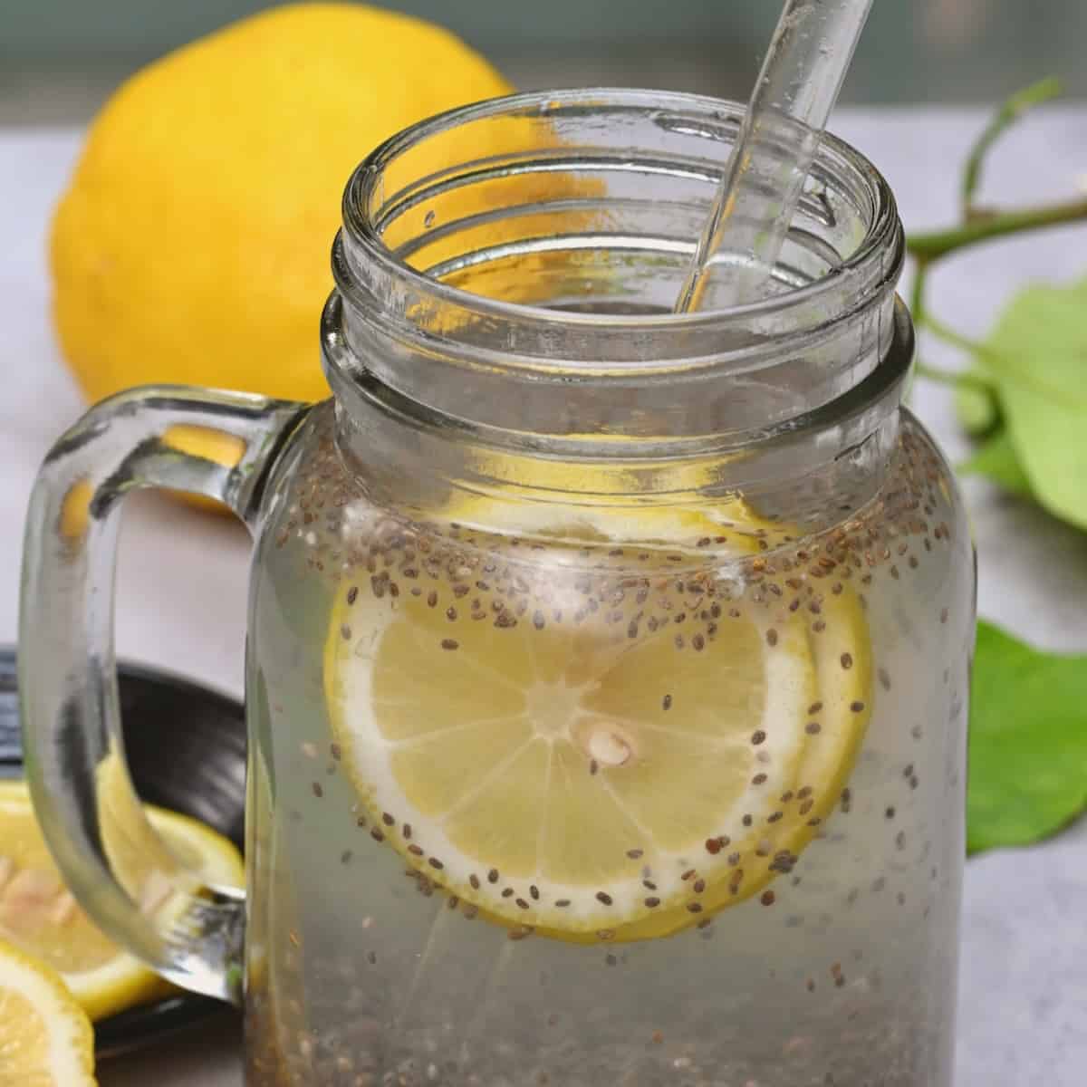 Chia seed water with lemon slices and a glass straw in a mason jar