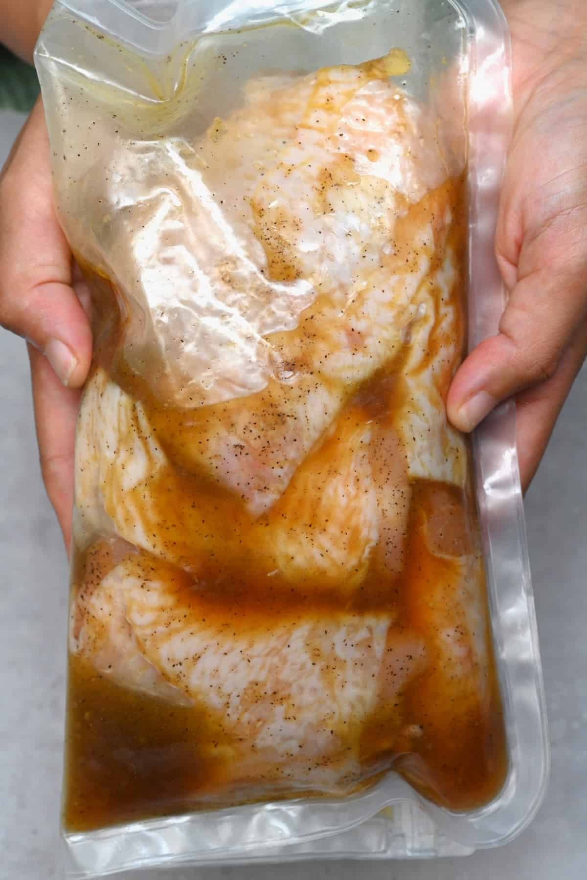 Chicken marinating in a reusable bag