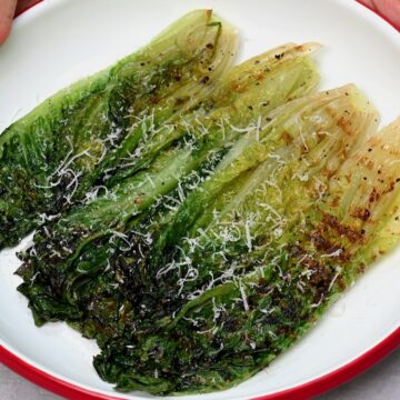 Grilled lettuce topped with grated parmesan cheese