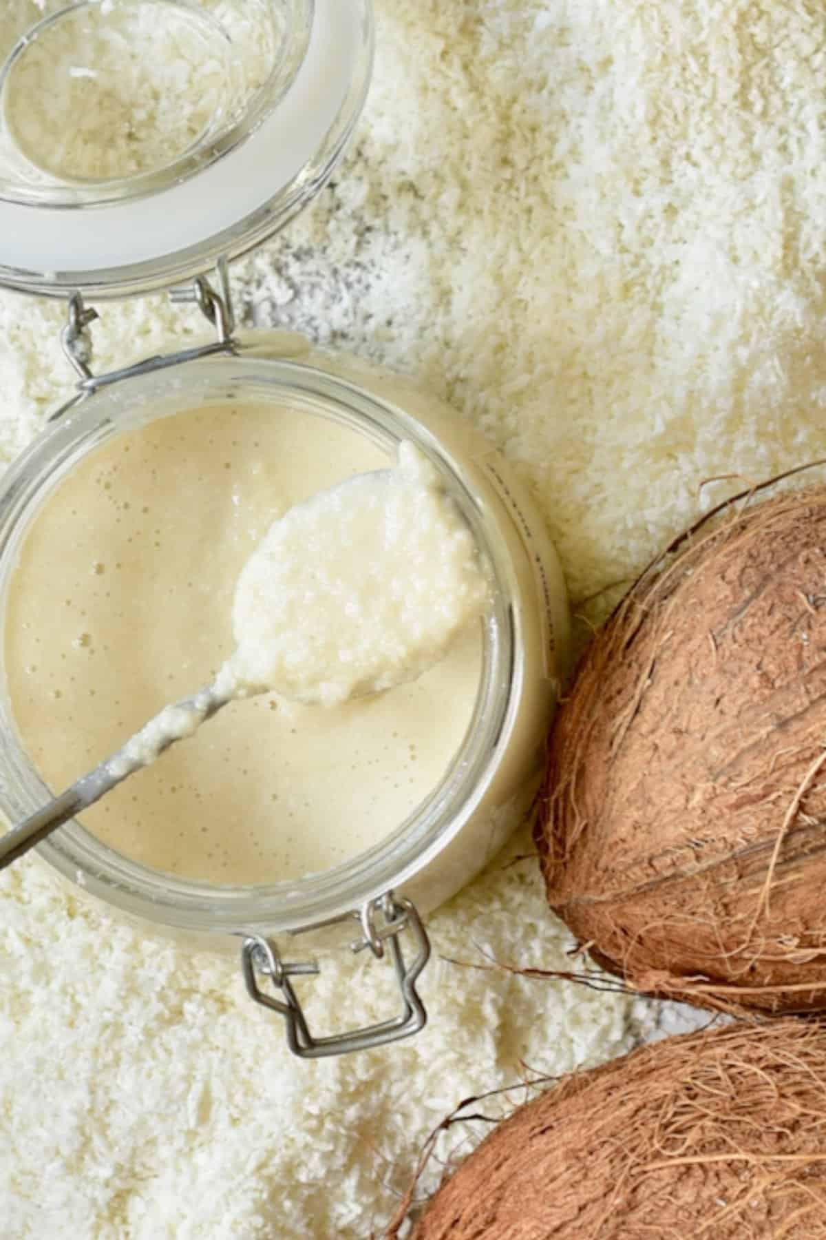 A spoonful of homemade coconut butter over a jar
