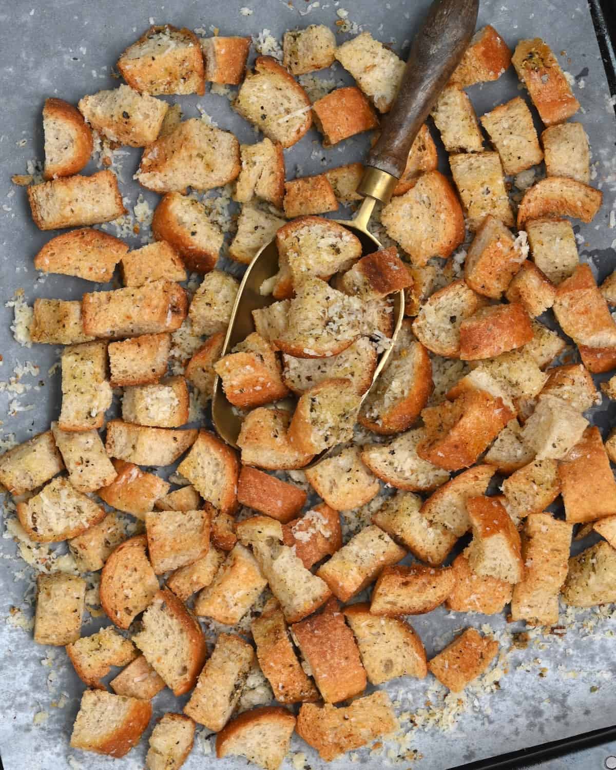 Homemade croutons topped with parmesan on a baking tray