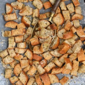 Homemade croutons topped with parmesan on a baking tray
