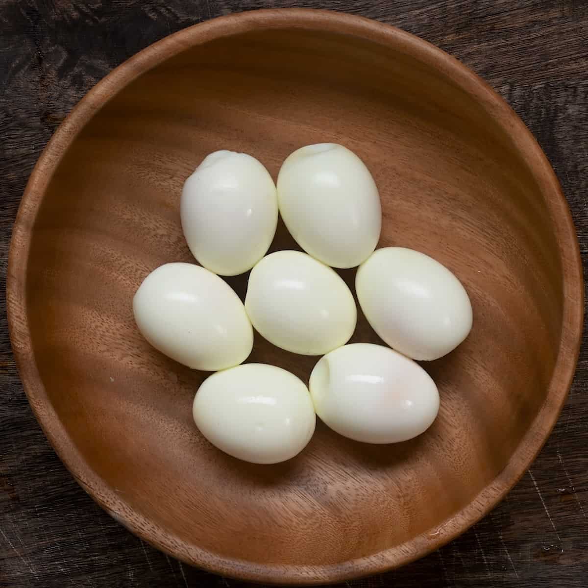 Seven peeled boiled eggs in a bowl
