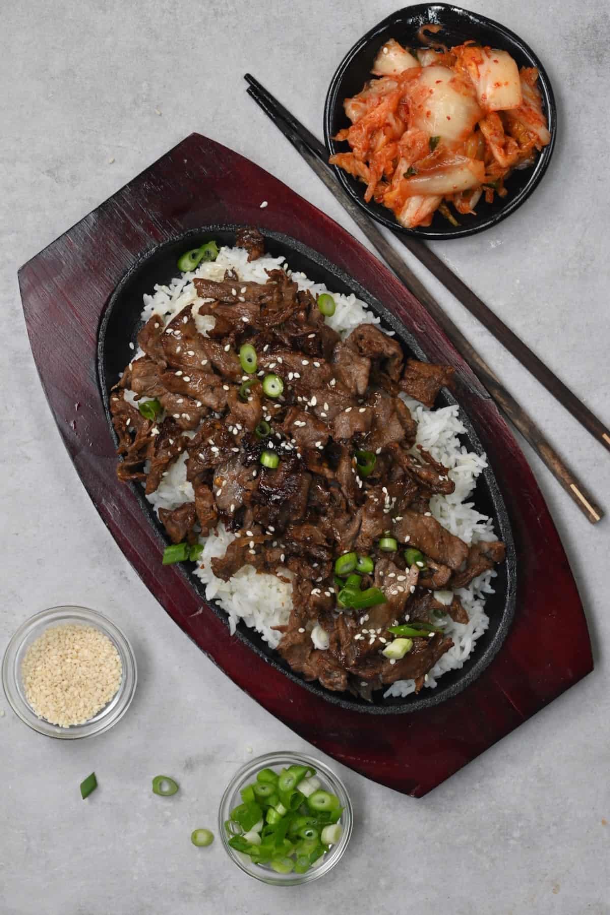 A serving of Korean beef over rice with a side of kimchi