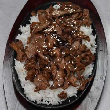 A serving of Korean beef over rice topped with sesame seeds