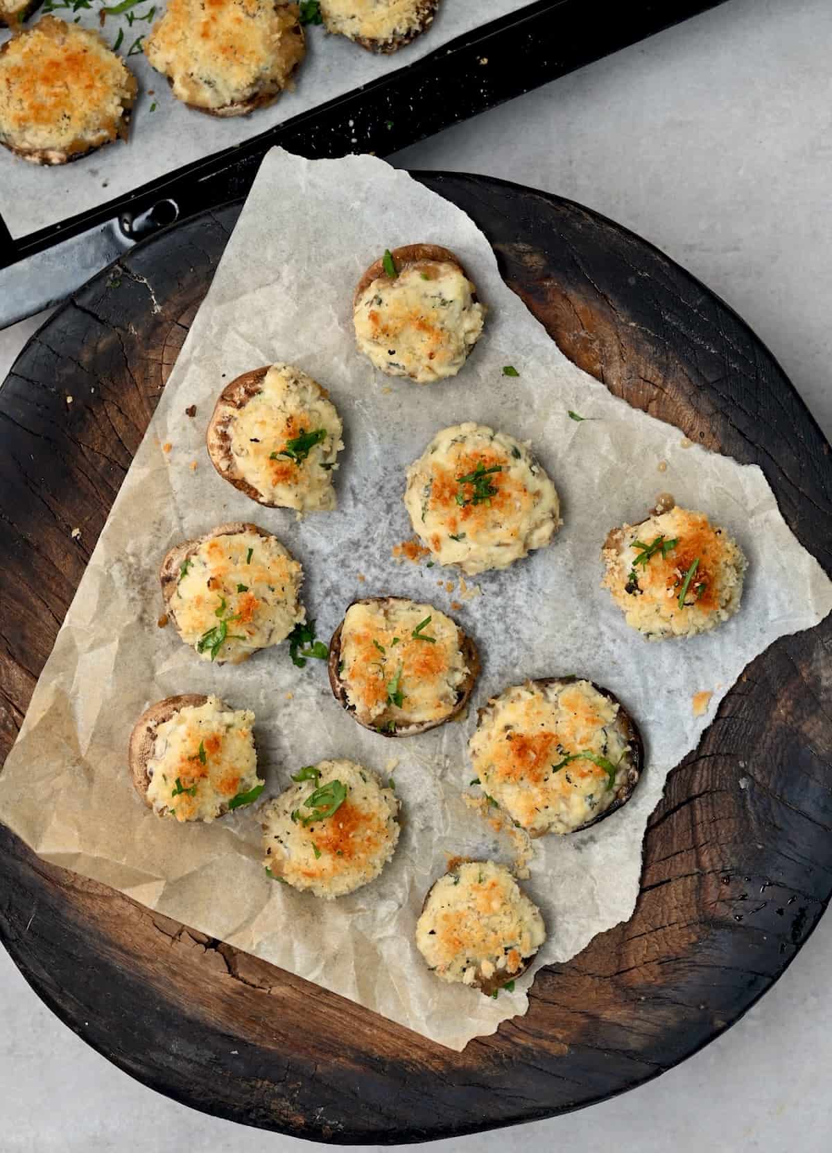 A platter with baked stuffed mushrooms topped with parmesan