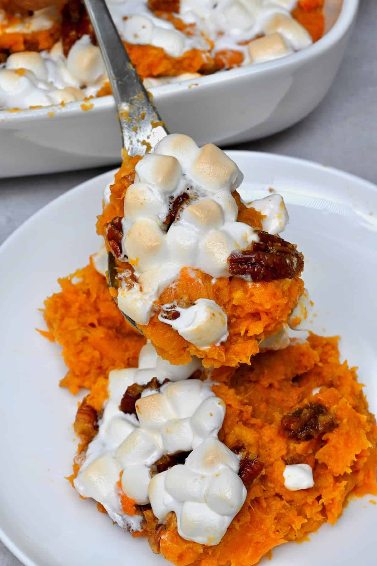 A spoonful of sweet potato casserole topped with marshmallow