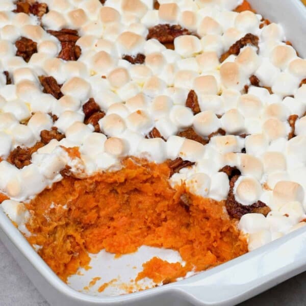 A baking dish with sweet potato casserole topped with marshmallow