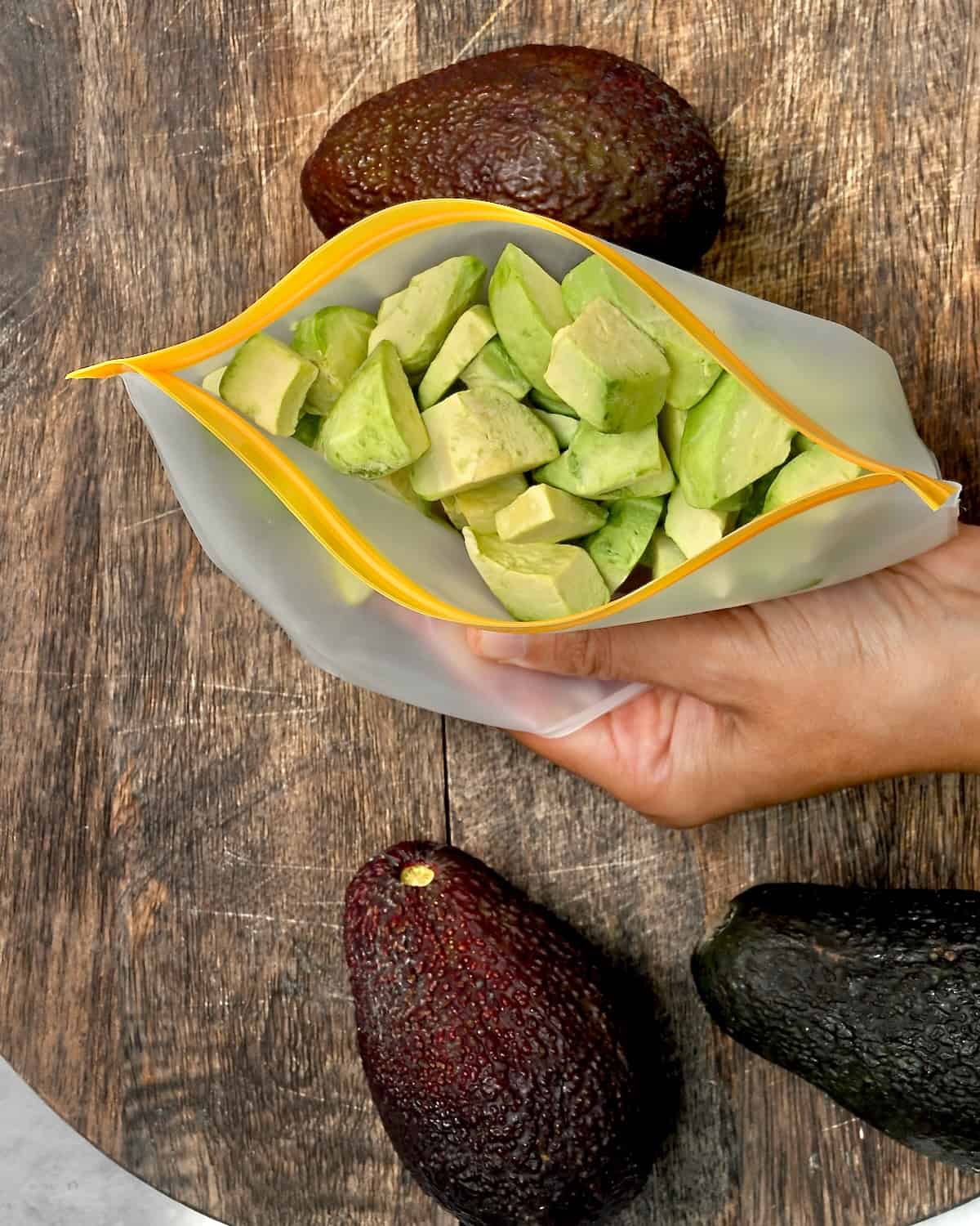 A reusable freezer bag with frozen avocado chunks