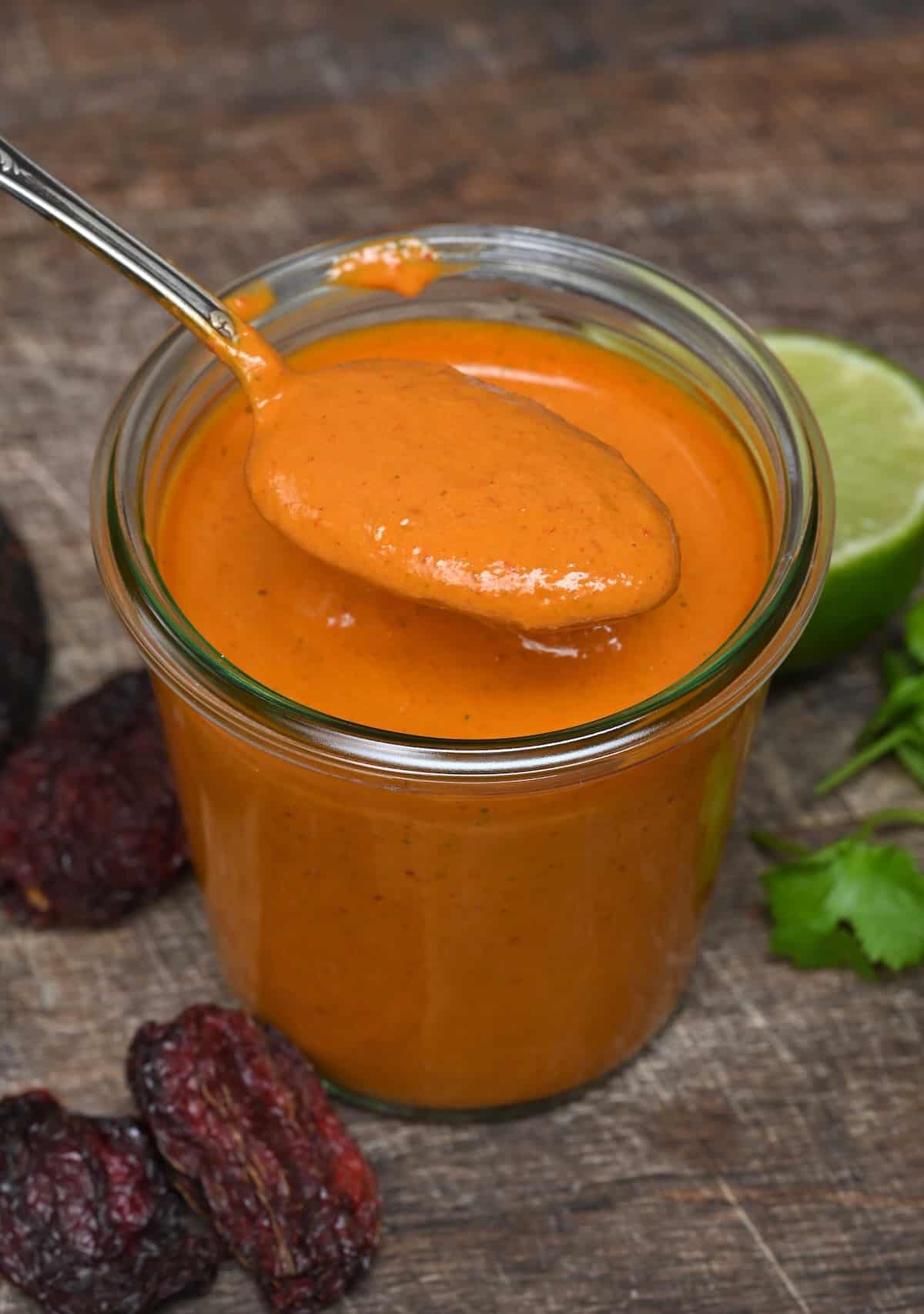 A spoonful of chipotle sauce over a jar