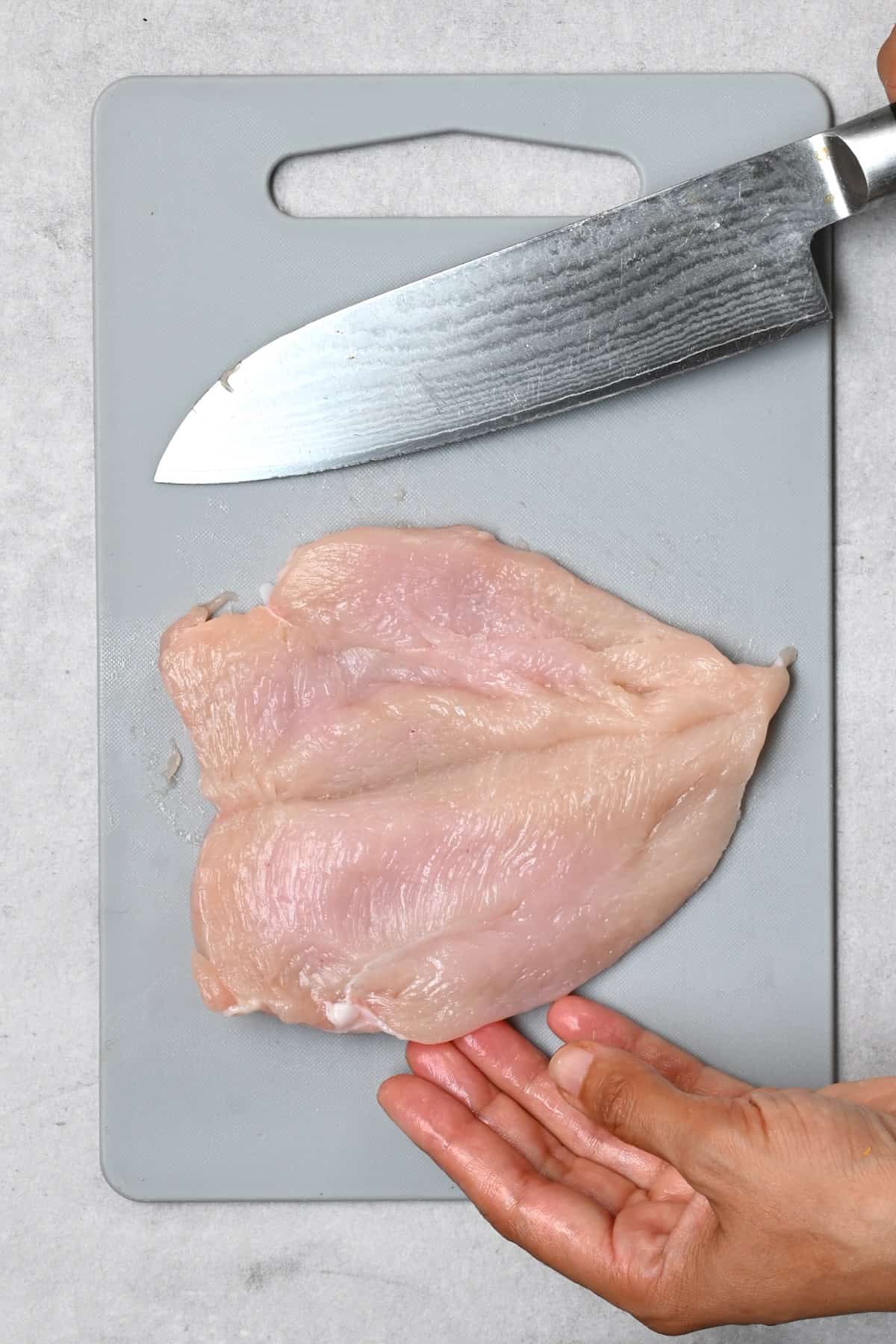 Butterflied chicken breast fillet on a cutting board