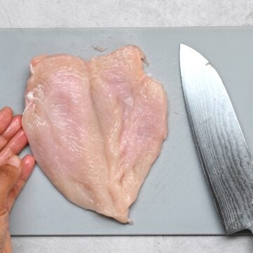 Butterflied chicken breast fillet on a cutting board