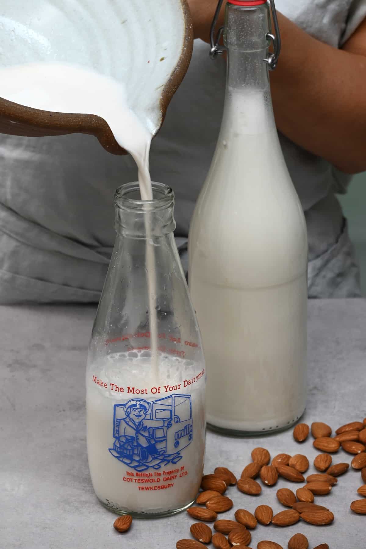 Pouring homemade almond milk in a bottle