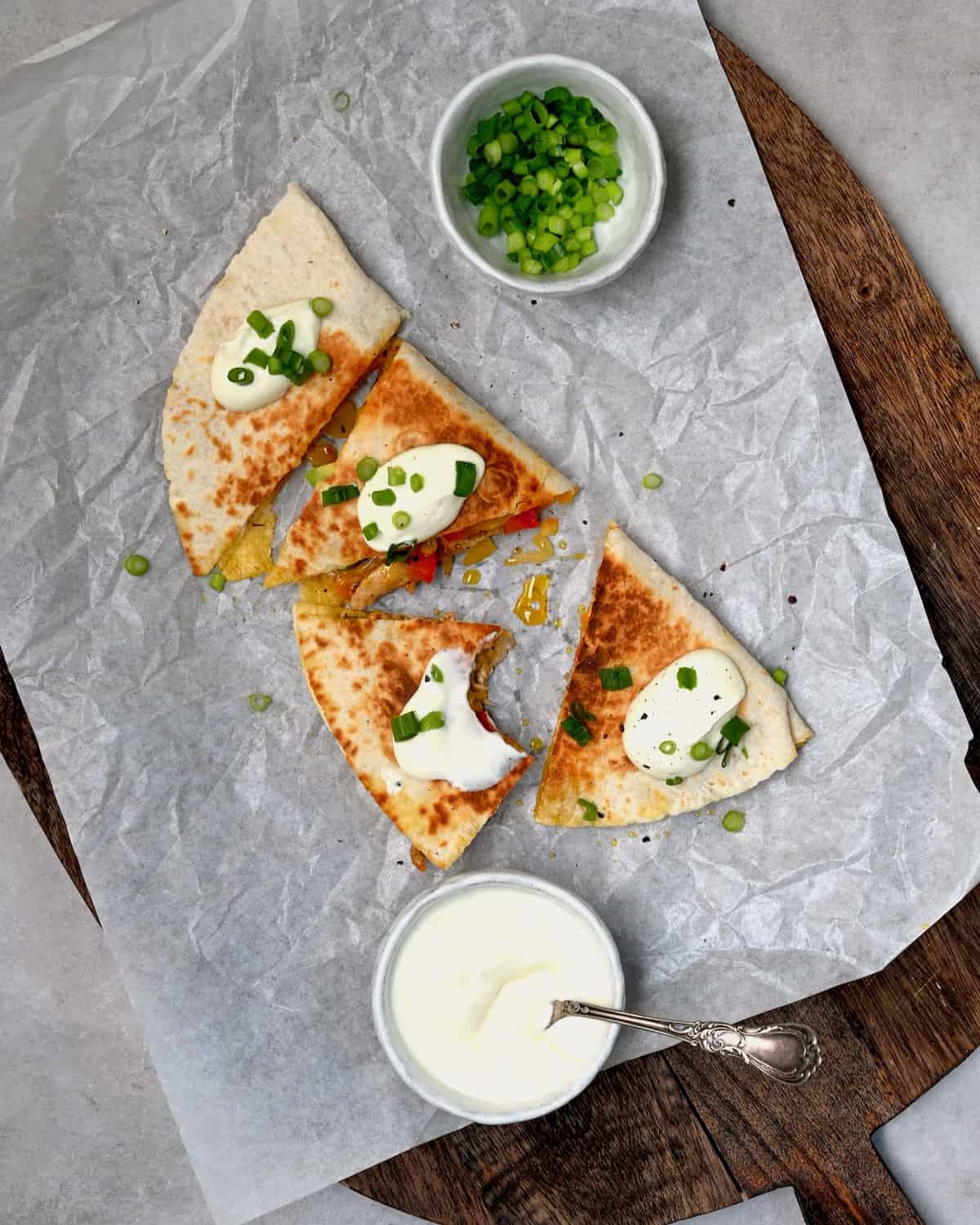 Chicken quesadilla cut into four and topped with sour cream