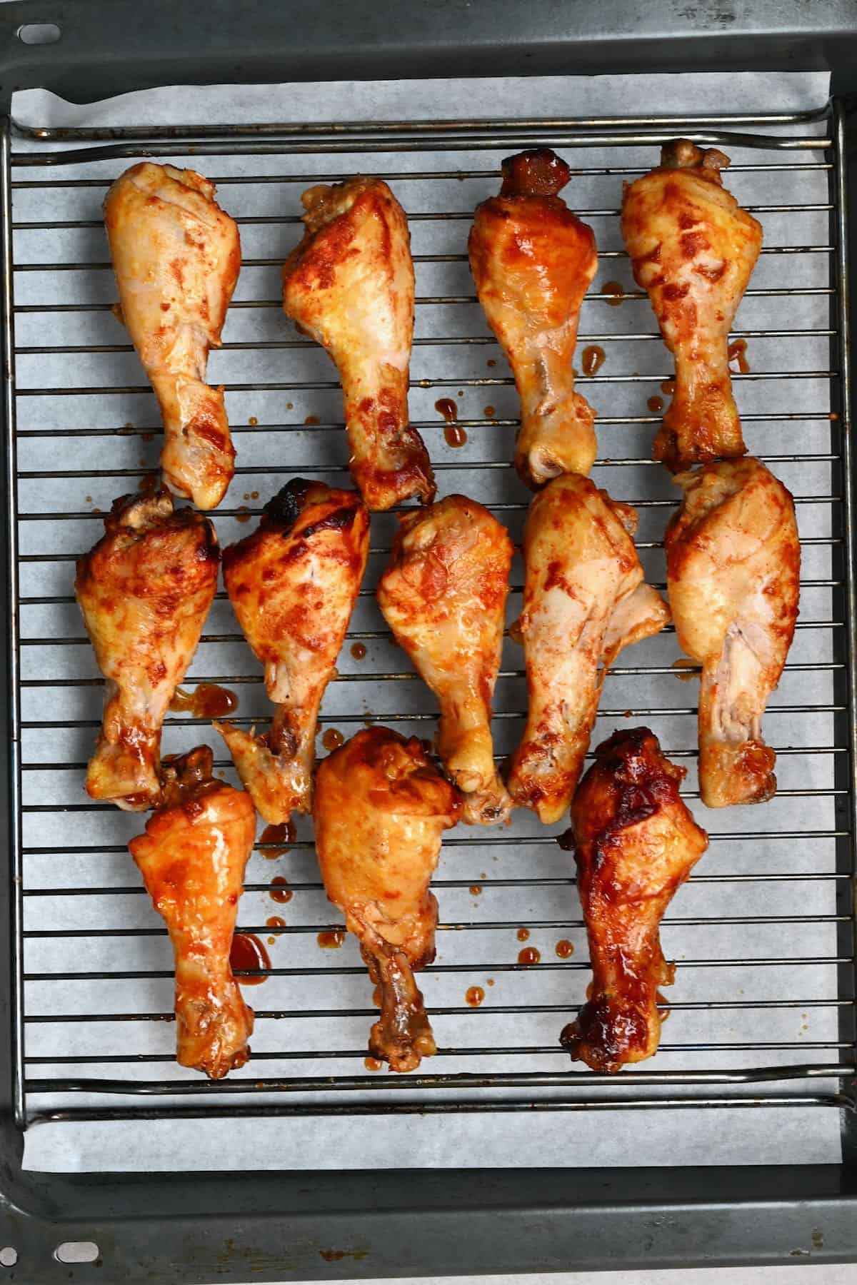 Crock pot chicken drumsticks on a baking tray before broiling