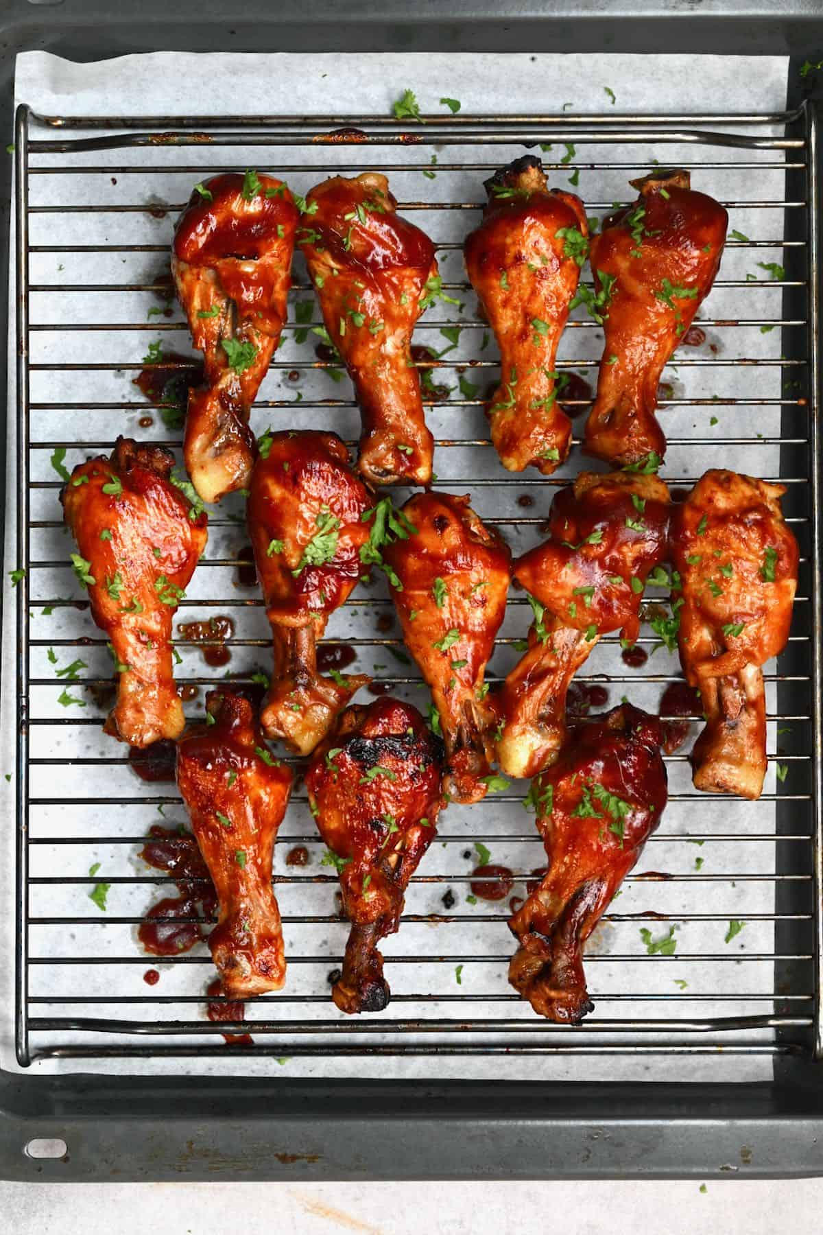 Crock pot chicken drumsticks on a baking tray after broiling