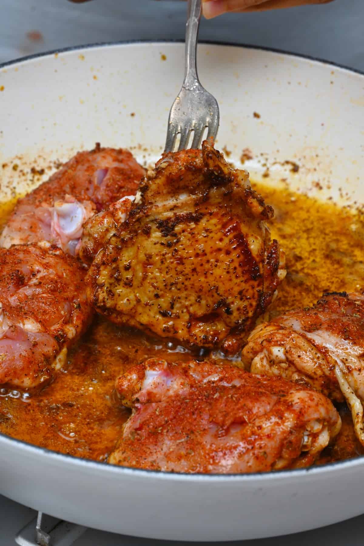 Crisped chicken thighs in a pan