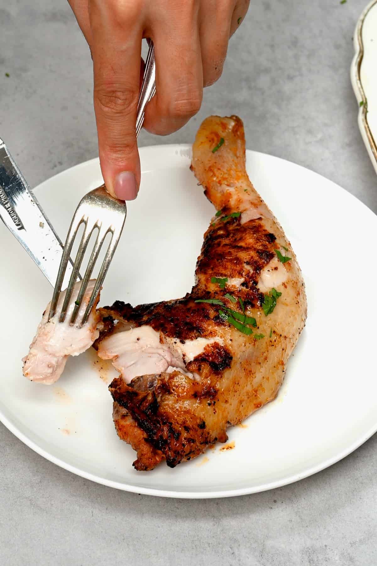 Grilled chicken quarter served on a plate