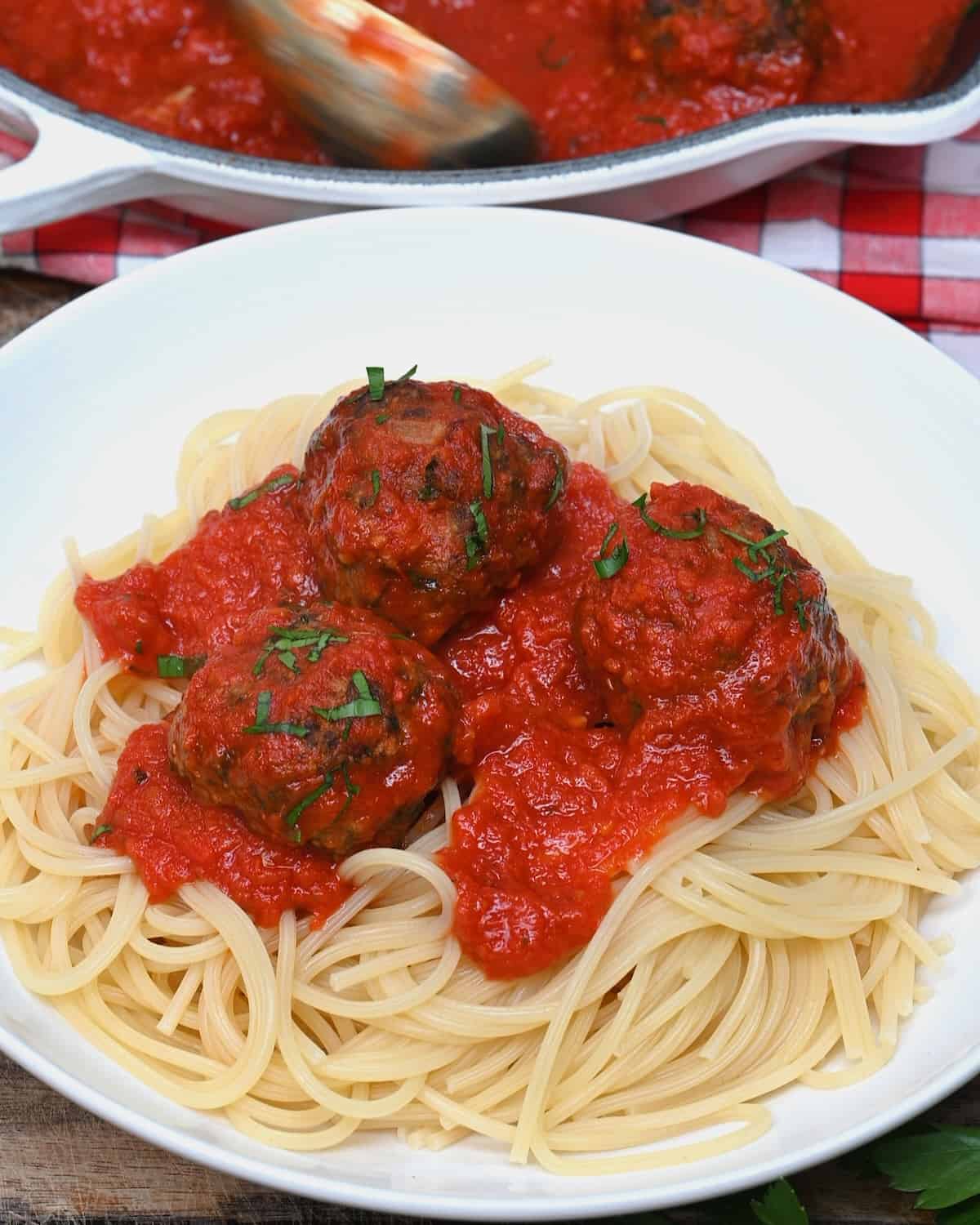 A serving of spaghetti with Italian meatballs in marinara sauce