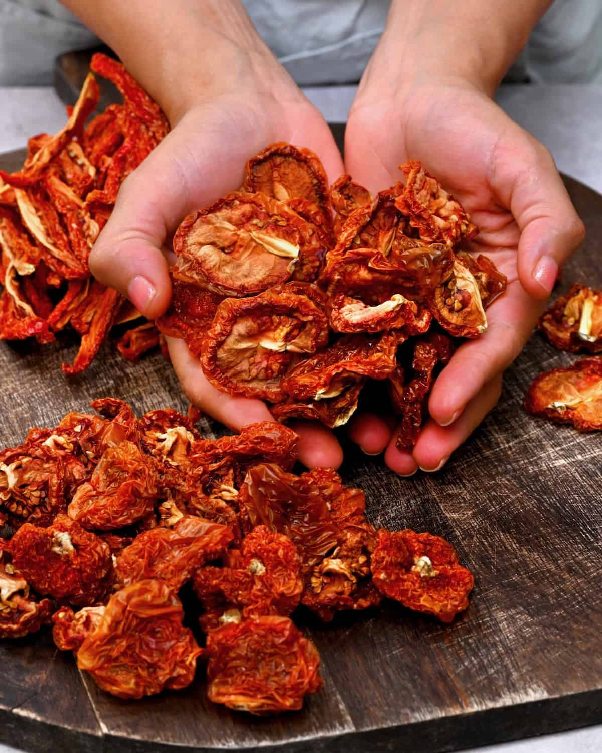A hand holding a bunch of dried tomatoes
