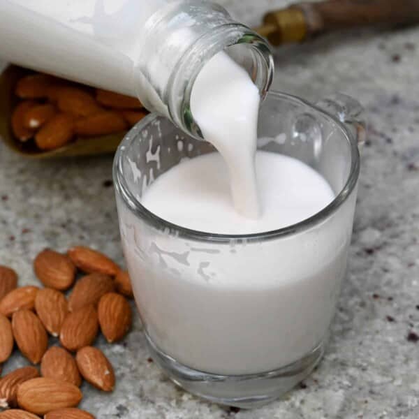 Pouring almond milk in a cup
