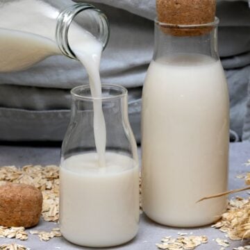 Pouring homemade oat milk into a bottle