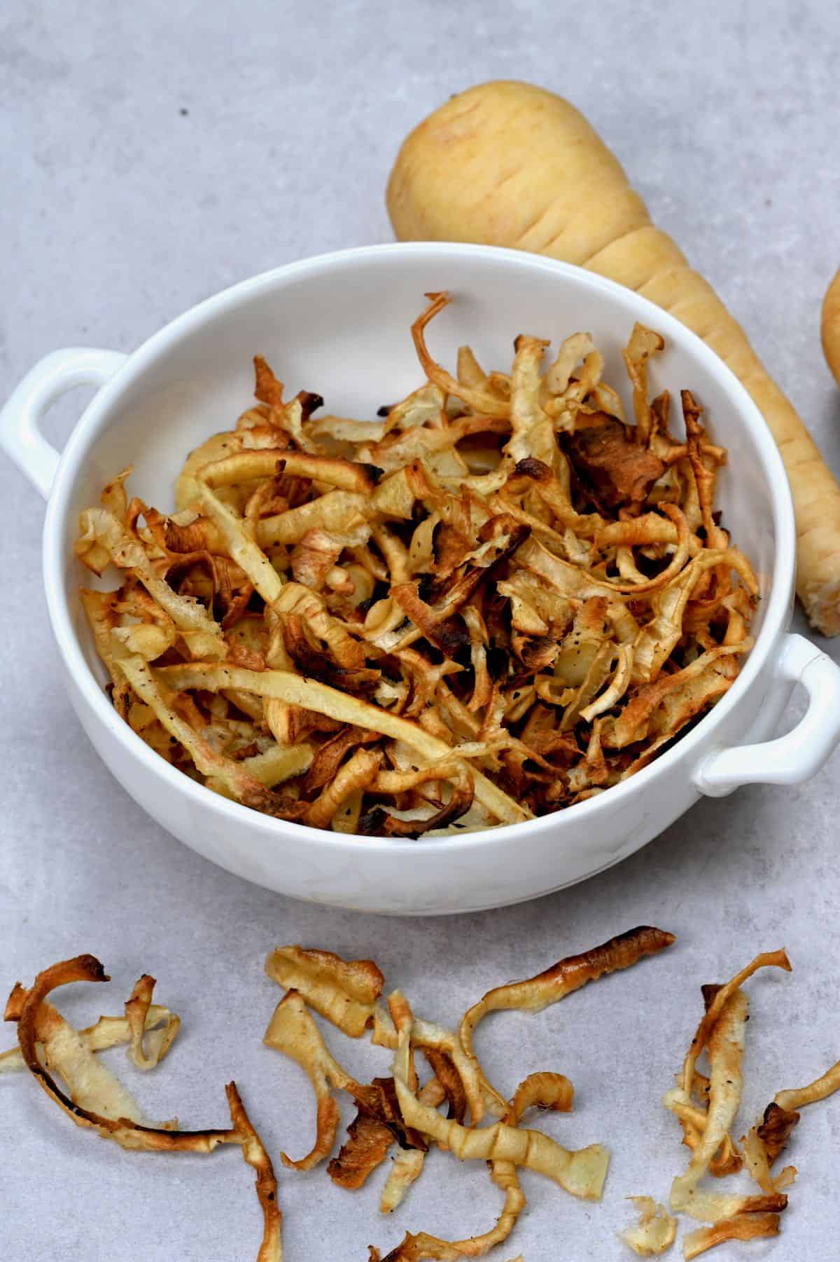 Parsnip peel chips in a white bowl