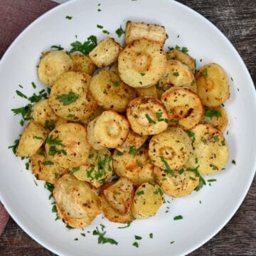Roasted Parsnips in a plate with chopped parsley