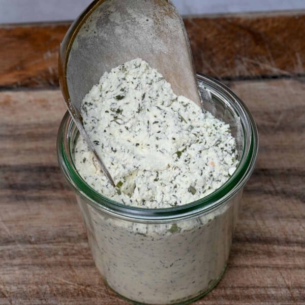 side view filling a glass jar with ranch dressing mix