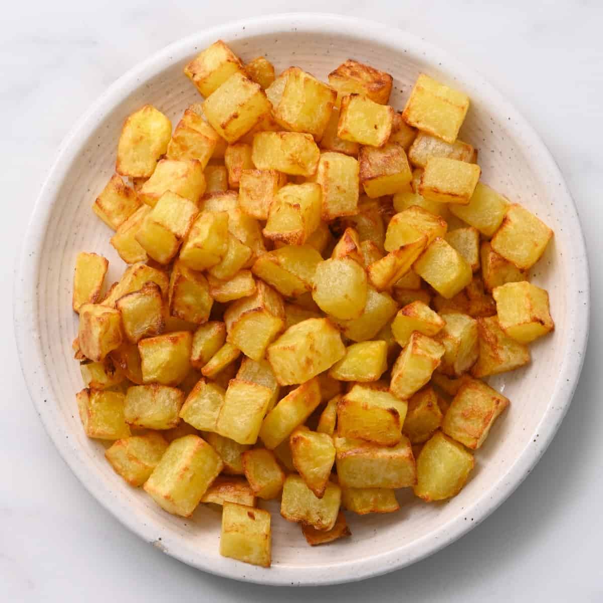 A plate with cooked chopped potatoes