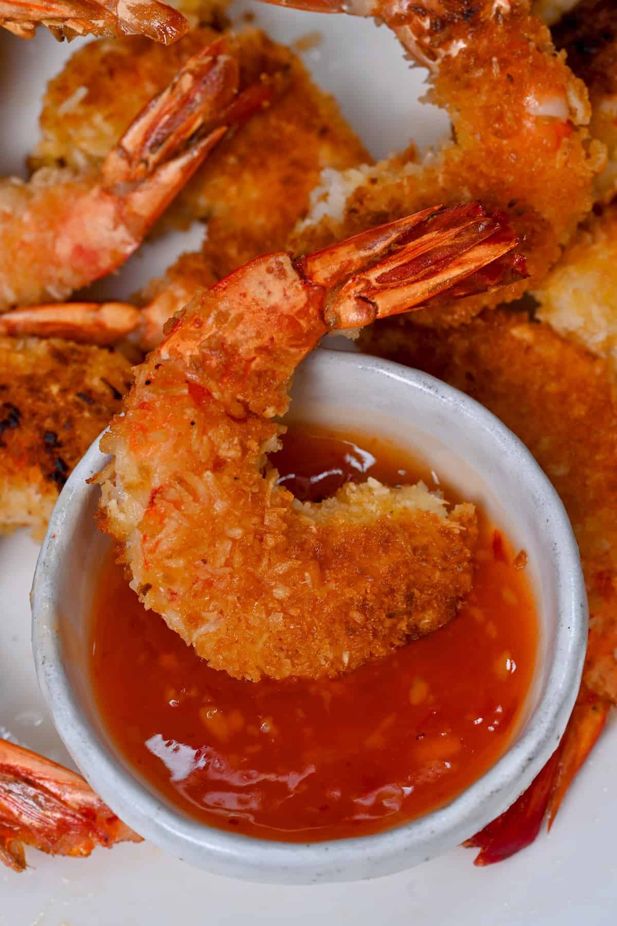 Dipping one fried shrimp in red sauce