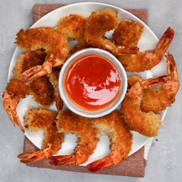 A plate with coconut shrimp and a small bowl with chili sauce