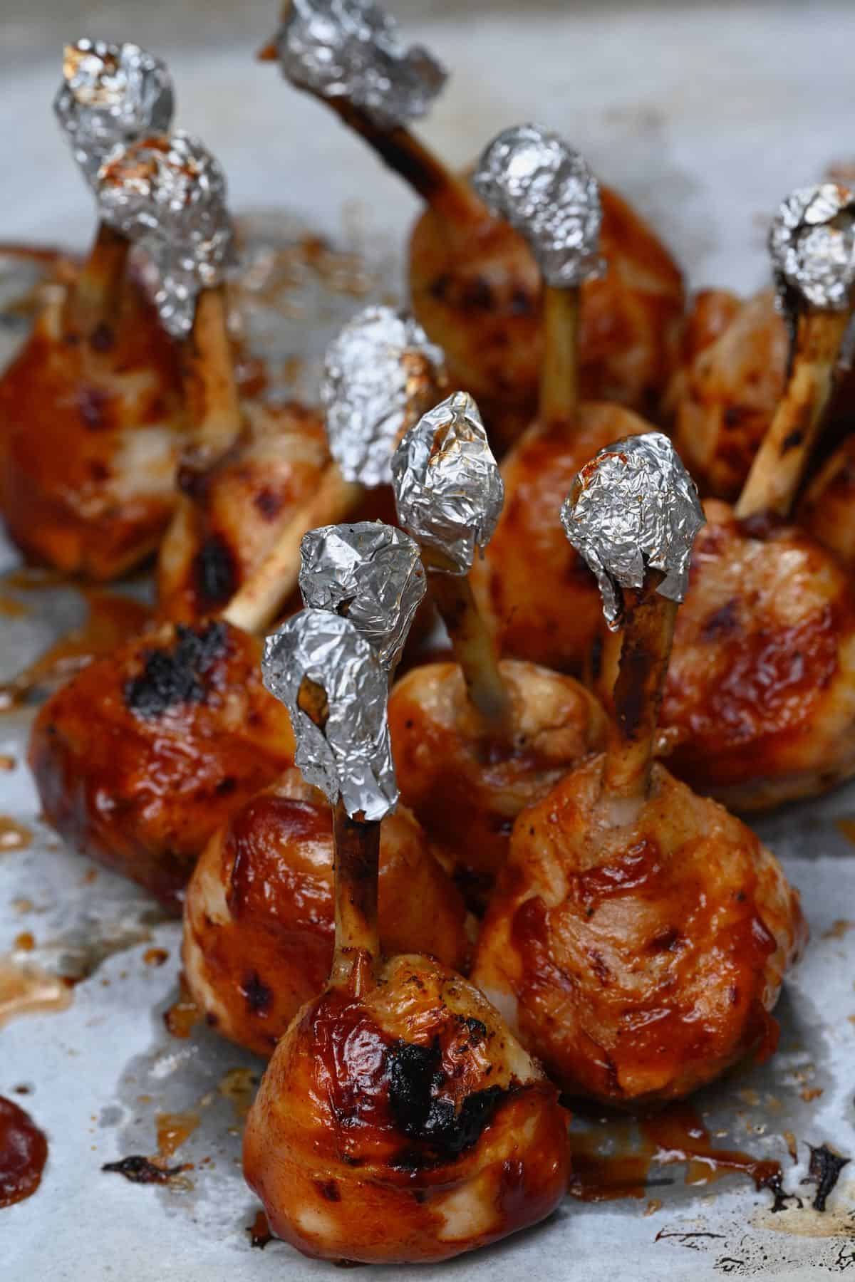 side view of chicken lollipops with foil at the top