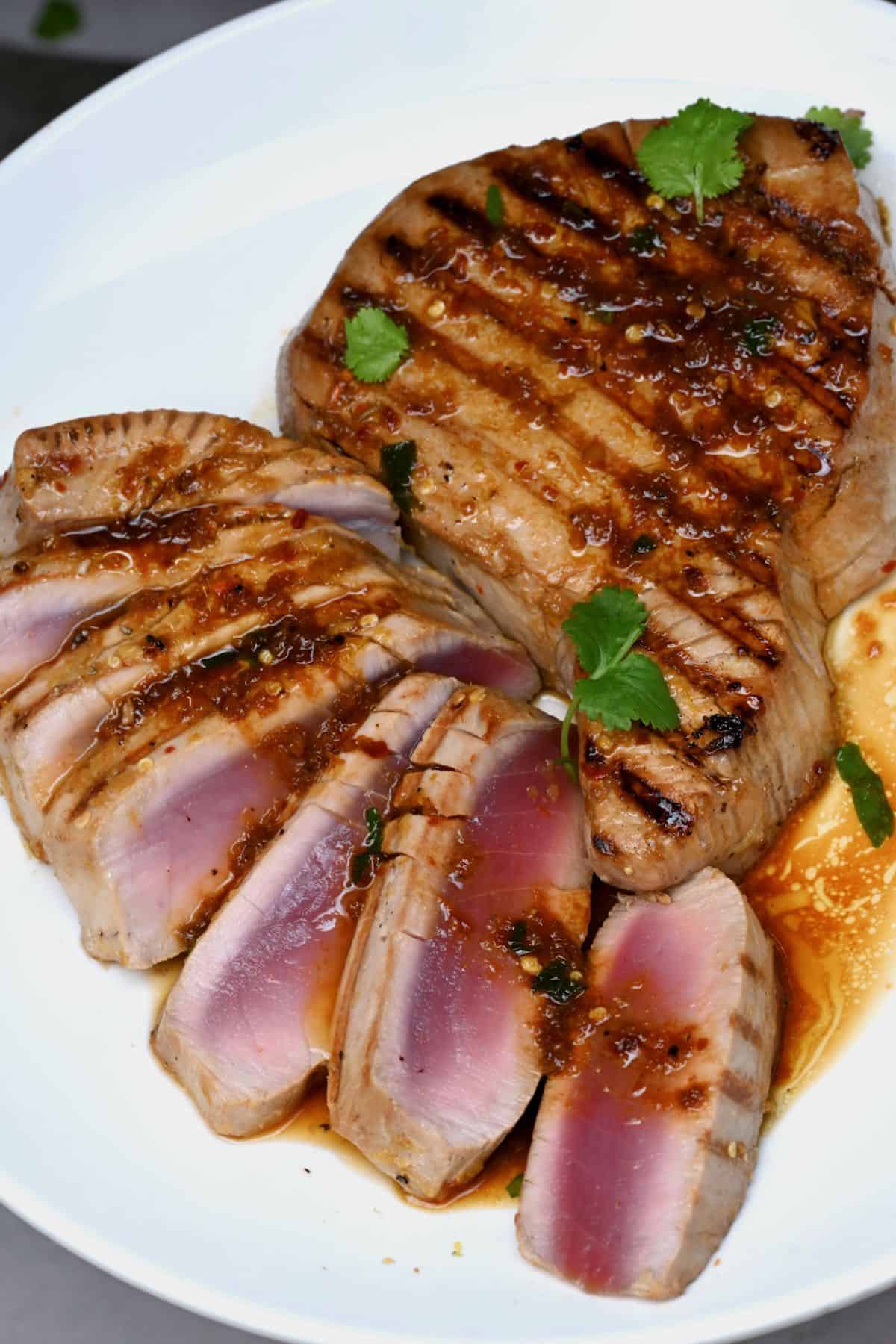 grilled and sliced tuna steak on a white plate