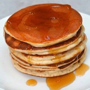 A stack of protein pancakes covered with maple syrup