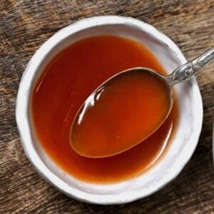 A spoonful of sweet and sour sauce over a small bowl