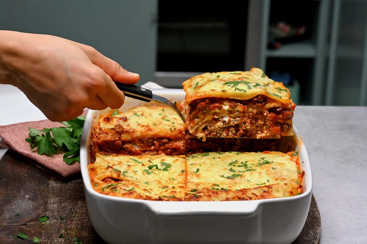 Taking a slice of lasagna out of a baking dish