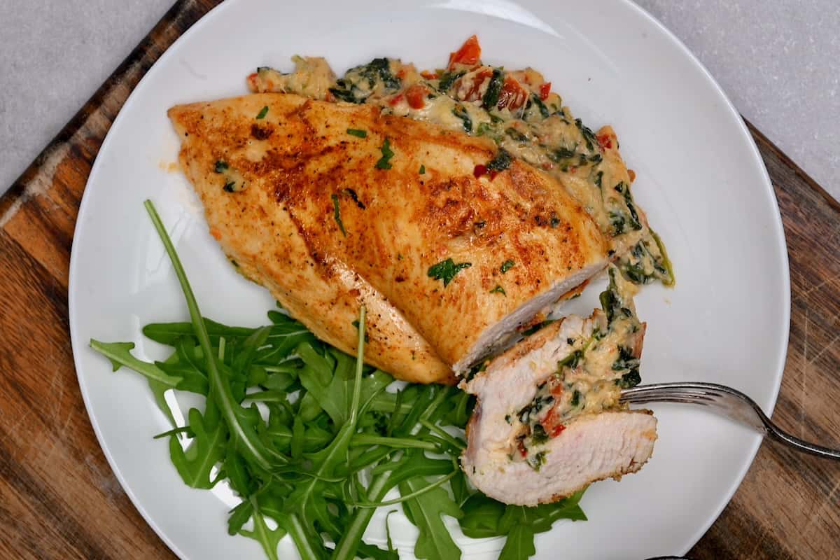 Cheese stuffed chicken breast served with roquette salad