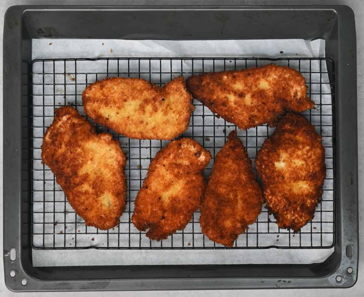 transfering the fried chicken on a wire rack.