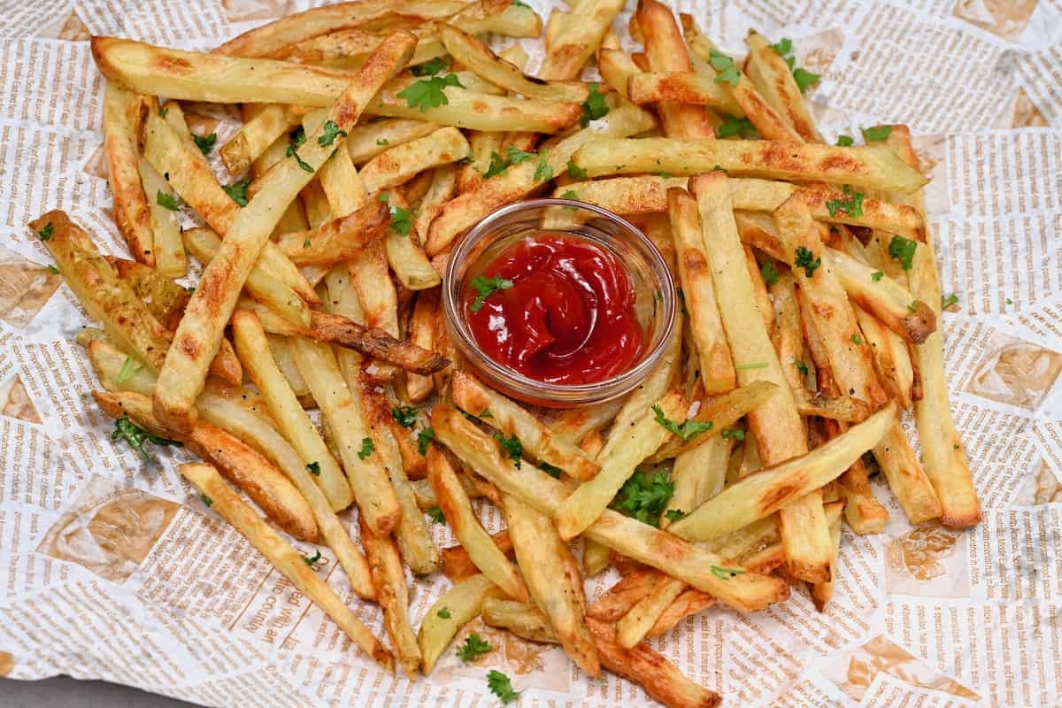 A serving of baked French fries with ketchup