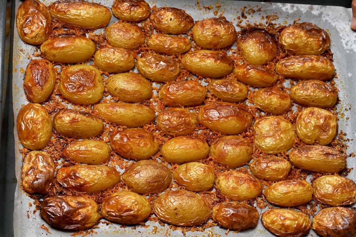 Golden brown baked potatoes in a baking tray