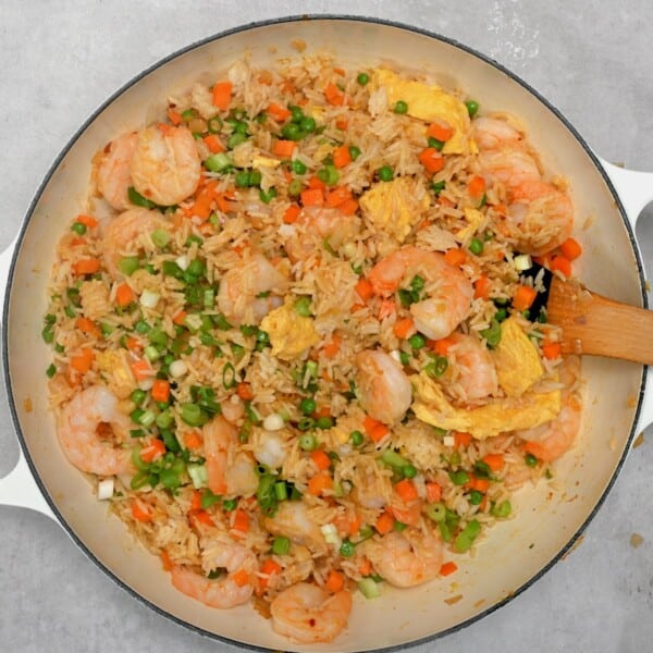 A large skillet with shrimp fried rice
