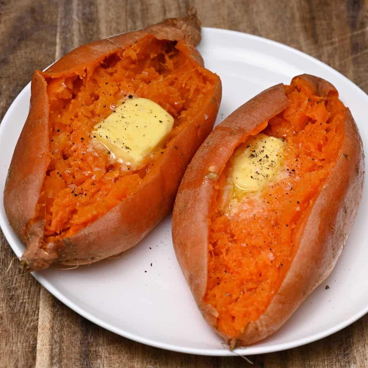 Two microwaves sweet potatoes topped with a bit of butter and pepper