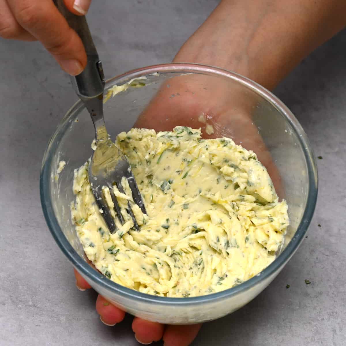 Mixing the butter herb mixture with fork