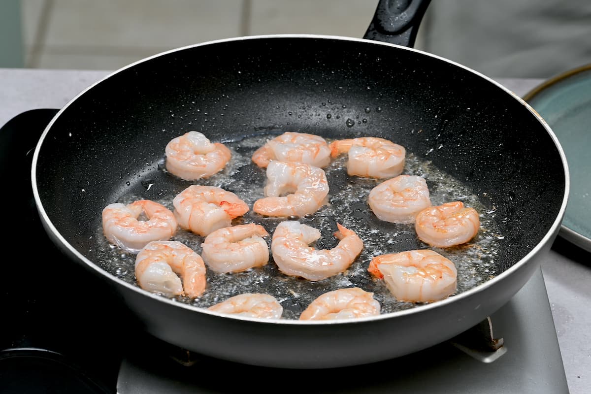 Sautéing shrimp in a pan