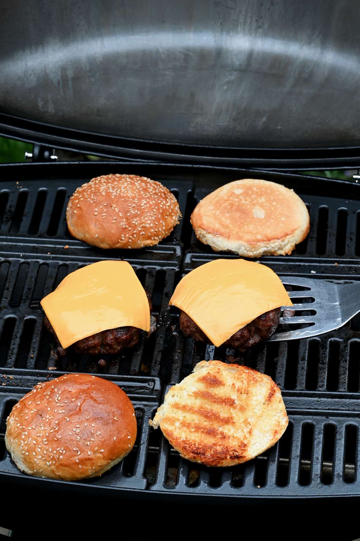 Melt cheese on the grilled patties.